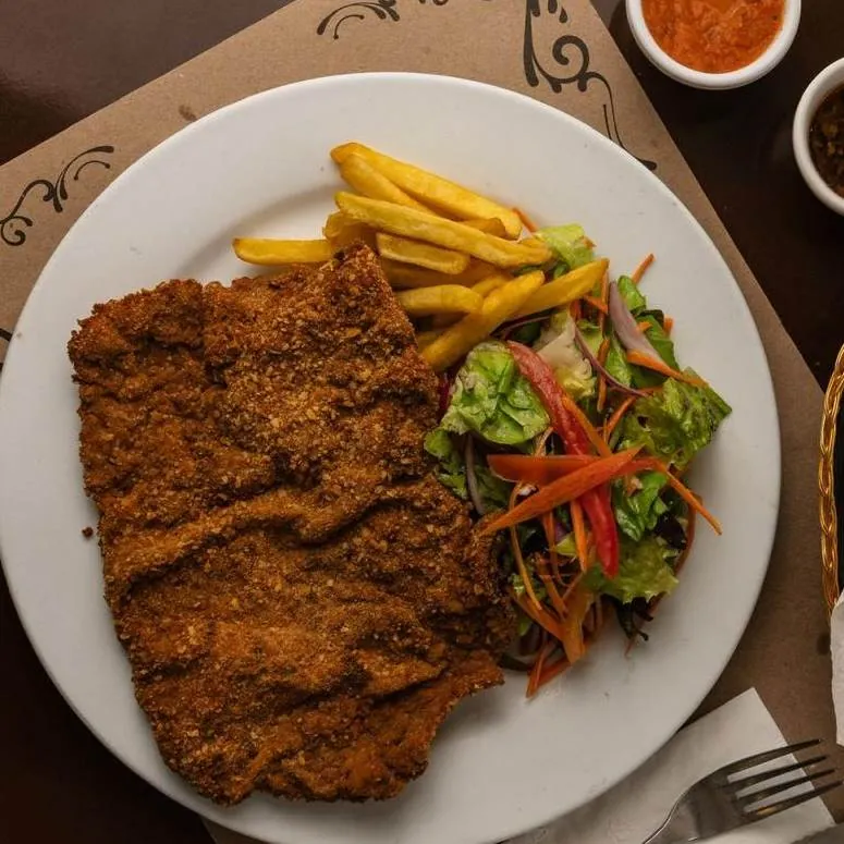 Milanesa con papas fritas y ensalada en La Vaca Gaucha